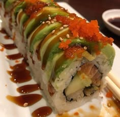 a sushi roll with sauce and garnish on it