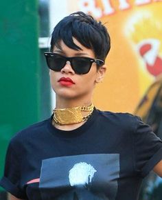 a woman wearing sunglasses and a t - shirt with a gold chain around her neck