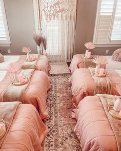 a bed room with four beds covered in pink blankets