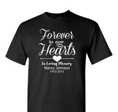 This unisex Memorial T-shirt is crafted with premium cotton for a lasting, comfortable fit. Featuring a heartfelt design with "Forever in our Hearts" on the back, it's a warm and touching symbol to honor a lost loved one. This "Forever in our Hearts" Memorial T-shirt with a name and a date is a beautiful way to keep that person gone to soon close to your heart at all times. Say it proudly with this made to order garment. Personalization comes at no extra charge. Shown in black and Navy Blue SHIR In Loving Memory Tshirt Design, In Loving Memory Shirt, In Loving Memory T Shirts Ideas, R I P Shirts Ideas, Memorial T Shirts Ideas Design, Black Heart-shaped Graphic Tee, Rip Tshirt Ideas, Memorial Tshirt Ideas With Picture, Rip Shirts Ideas With Picture