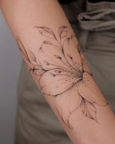 a woman's arm with a flower tattoo on it