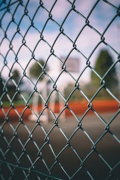 a tennis court seen through a chain link fence