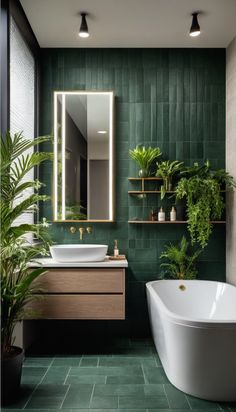 a bathroom with green tiles and plants on the wall, along with a white bathtub