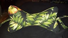 a black and green pillow with flowers on it