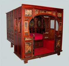 an elaborately carved wooden bed with red carpet