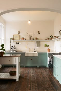 a kitchen with wooden floors and blue cabinets