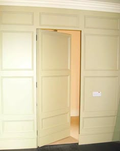 an open door leading to another room with white walls and black carpeted flooring