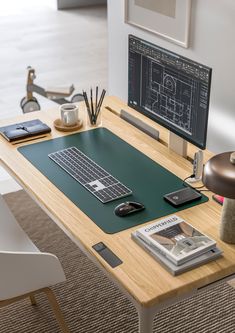 a wooden desk with a computer monitor, keyboard and mouse sitting on top of it