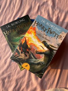 two harry potter books sitting on top of a bed next to an elephant and dragon