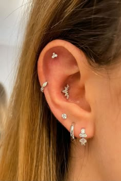 a close up of a person's ear with three different piercings on it