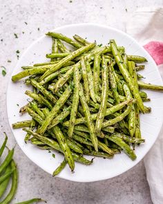 asparagus on a white plate with parsley sprinkled in seasoning