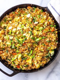 a skillet filled with fried rice and vegetables