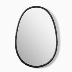 an oval mirror with black leather trim around the edges, hanging on a wall in front of a white background