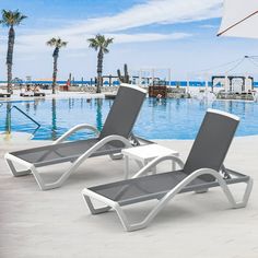 two lounge chairs sitting next to a swimming pool