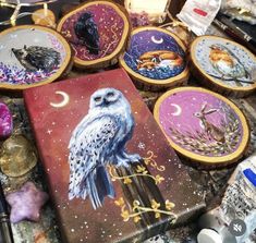 a table topped with lots of different types of embroiderys on wooden hoop holders covered in fabric