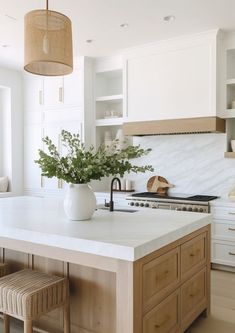 a white kitchen with an island and wooden stools in front of the countertop