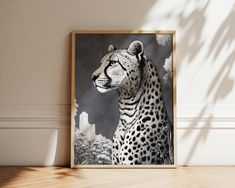 a black and white photo of a cheetah in front of a wall with a plant