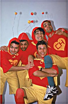 a group of men in red and yellow outfits posing for a photo together with balloons