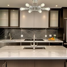 a modern kitchen with marble counter tops and stainless steel appliances