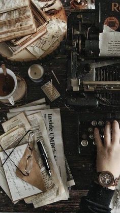 a person typing on an old typewriter surrounded by papers, keys and other items