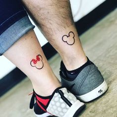 two people with matching mickey mouse tattoos on their legs, one has a red bow