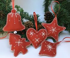 three red ornaments hanging from a christmas tree