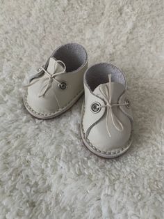 a pair of baby shoes sitting on top of a white rug