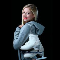 a woman in grey sweater holding a white skateboard