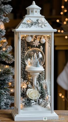 a snow globe is sitting on top of a table next to a christmas tree and lights