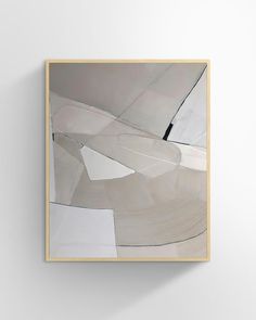 an abstract painting with white and grey colors on the wall above it is a wooden frame