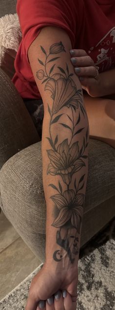 a woman's arm with flowers on it and the word love written in cursive writing