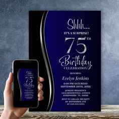 a person holding up a cell phone in front of a blue birthday party card that says, shih it's an surprise 75th birthday celebration