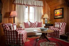 a living room with red and white checkered couches, chairs and rugs