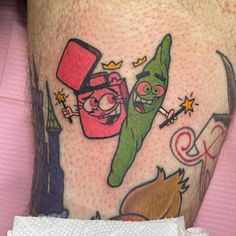 a person with a tattoo on their leg that has two cartoon characters and one is holding a knife