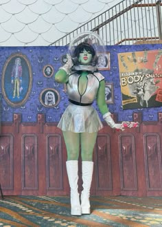 a woman dressed in costume standing next to a wall