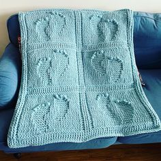 a crocheted blanket sitting on top of a blue couch