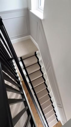 an overhead view of a stair case in a house with carpeted floors and white walls