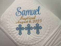 a close up of a white towel with blue cross embroidered on the front and back