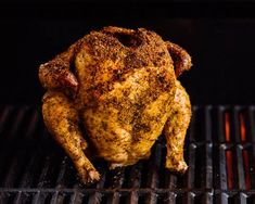 a chicken sitting on top of a bbq grill