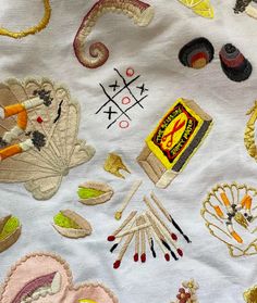 an assortment of embroidered objects on a white cloth