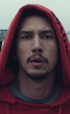 a man in a red hoodie looking at the camera