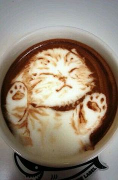 there is a coffee art in the shape of a cat on it's face