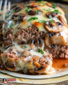 a plate topped with lasagna covered in cheese and mushrooms