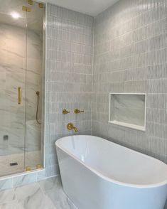 a white bath tub sitting inside of a bathroom next to a walk - in shower