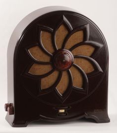 an old fashioned radio is sitting on a white surface with a brown and tan flower design