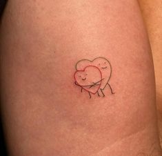 a small heart tattoo on the back of a woman's thigh