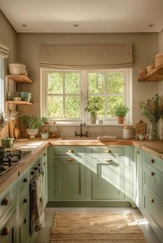 a kitchen filled with lots of green cupboards and counter top next to a window