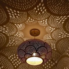 an overhead view of a light fixture in a room with circular patterns on the ceiling