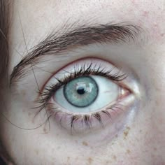 a close up of a person's eye with brown hair