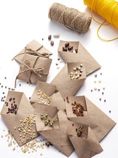 several pieces of craft paper are laid out on a table with twine and spools of thread